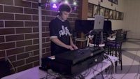 a young man playing a dj in a room