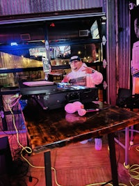 a man sitting at a table with a dj set up
